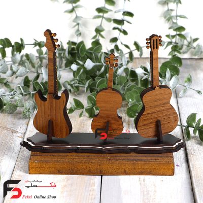دکوری ساز چوبی سه نواز که در آن سازهای گیتار کلاسیک و گیتار الکتریک و ویالون وجود دارند
